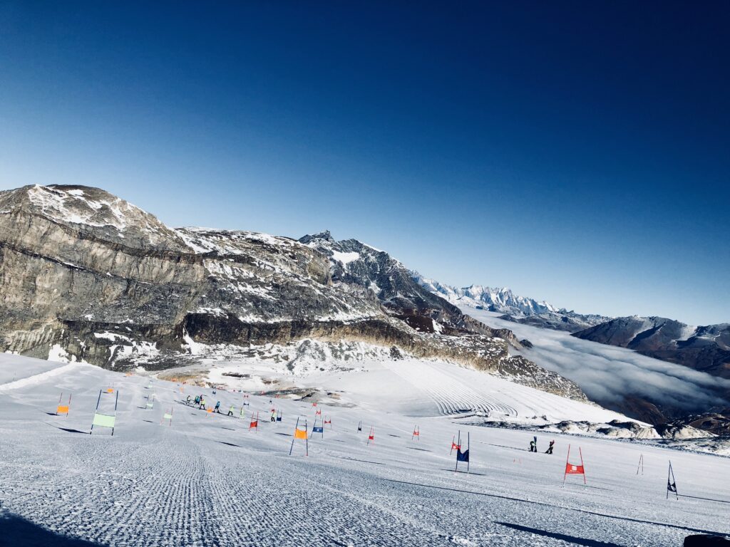 Entraînement de ski alpin sur glacier avec portes de slalom – Alpes – préparation hivernale